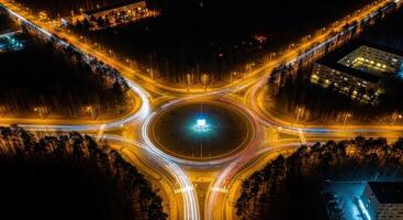 Aerial long exposure of a busy city roundabout at night with vibrant vehicle light trails photo