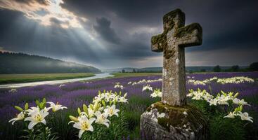 Ancient moss covered stone cross in a vibrant flower field with river and dramatic sky photo
