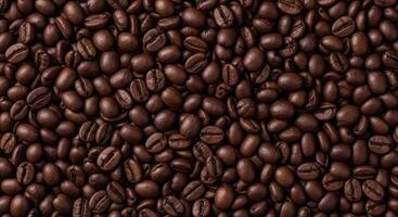 Close up top view of dark roasted coffee beans creating a rich textured background photo