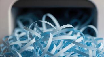 Light Blue Shredded Paper Pile Overflowing from a Container for Document Security photo