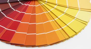Fanned out color swatch book displaying warm tones of red, orange, and yellow for design inspiration photo