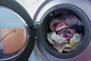 Washing machine loaded with clothes ready for a cycle photo