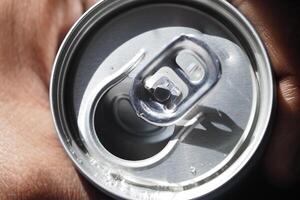 Top view of a opened beverage can in a person's hand photo