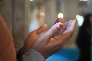 A person raises their hands in prayer, showing devotion and focus photo