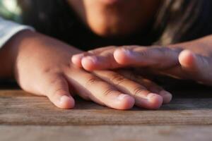 Hands resting on a wooden surface during golden hour photo