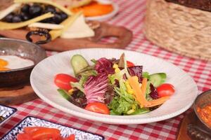Fresh and colorful salad with assorted ingredients on table photo