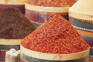 Vibrant spices displayed in a market during daytime photo