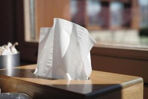 Tissue box on wooden table with sunlight streaming in photo