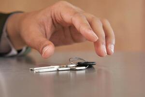 Hand reaching for keys on a table in a quiet setting photo