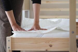 Setting up a new mattress on a bed frame in a bedroom photo