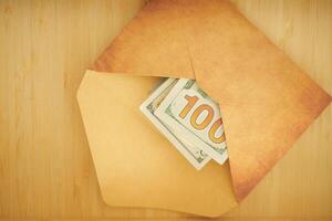 Money tucked in an envelope on a wooden background photo