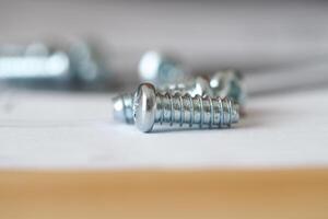 Close up of shiny screws on a work surface during assembly photo