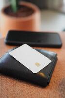 Wallet and card resting on wooden table near smartphone photo