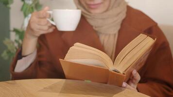 Enjoying a cozy reading moment with tea in a cafe video