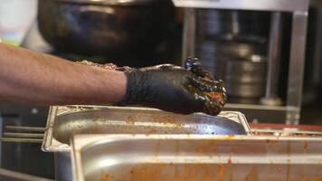 Preparing skewered meat in busy kitchen setting video