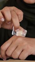 Using ice to soothe a hand during a wellness practice video