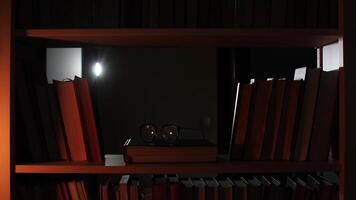 A book shelf with a lamp and a pair of glasses video