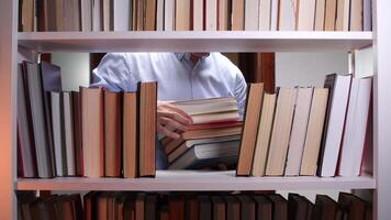 A man is looking at a bookcase video