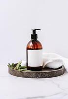 Mockup for bathing products in the bathroom, spa shampoo, shower gel, liquid soap with a towel beside on white background photo