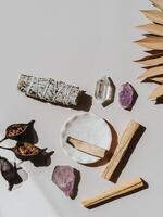 White sage and Palo Santo and amethyst and quartz crystals on a light beige background. photo