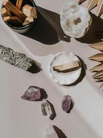 White sage and Palo Santo and amethyst and quartz crystals on a light background photo