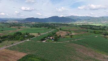 Drone shot flying above a mountain road surrounded by partially forested hills. The cloudy sky signals incoming rain, while the peaceful scene remains untouched and quiet. video