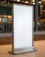 A blank sign on a table in front of a building photo