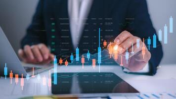 Businessman analyzing candlestick chart and stock market graph on digital dashboard, Showcase financial analysis, Trading strategy and investment trends in modern fintech and portfolio management. photo