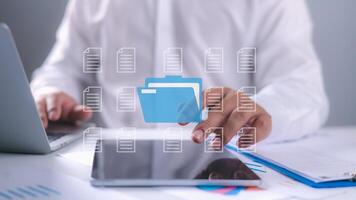 Businessman using laptop with holographic interface to access files, Showcasing cloud computing, digital file management, Data organization, and online document security technology. photo