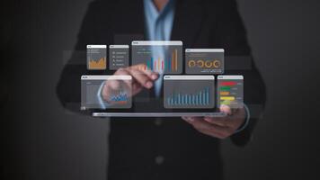 Business person holding a tablet displaying multiple holographic data charts, symbolizing comprehensive business intelligence, performance analysis, and digital dashboards. photo