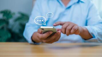 Person holding a smartphone with chat bubbles, representing online communication, social media, messaging, and digital connection. Ideal for customer service, networking, and virtual interactions. photo
