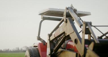 Young male farmer of European appearance turns a tractor, moving to a new lane while plowing an agricultural field on an autumn day photo