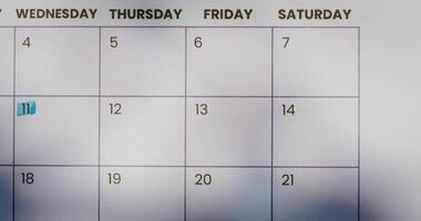 A woman crosses out a date on a calendar or a glider with a red marker. Close up of her hand, unrecognizable person photo