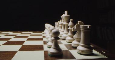 White chess pieces are lined up in rows on a game board, ready for a chess game, close up photo