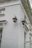 Elegant White Building With Classic Lanterns Illuminated at Dusk Showcasing Architectural Details and Charm in a Tranquil Urban Setting photo