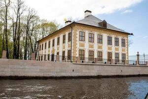 Historic Architecture Along the Waterfront in St Petersburg Showcasing Classic Design and Serene Surroundings Under a Clear Sky photo