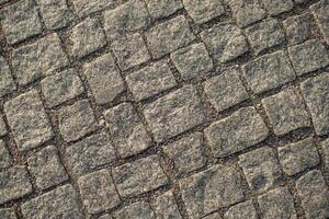 Uneven Cobblestone Pavement in Urban Setting Showcasing Intricate Stone Arrangement During Daylight Hours photo
