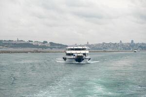Cruising through the Bosphorus Strait with city views on a cloudy day photo