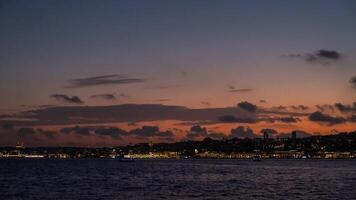 Sunset view over Bosphorus with city lights and clouds reflecting in the water photo