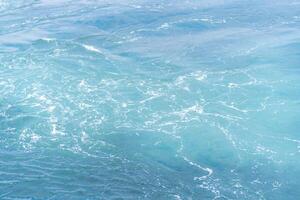 Waves gently lapping at the shores of Prince Islands during a sunny day with vibrant turquoise waters photo