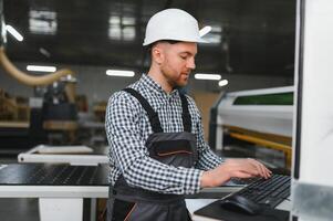 Carpenter programming cnc machine in furniture factory photo