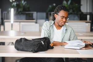 Focused university student studying textbook in library photo
