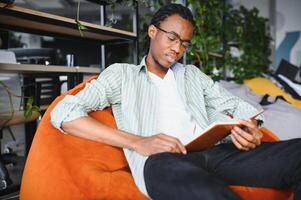 Focused university student reading a book in modern library. photo