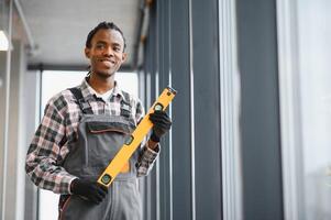 African American Skilled technician holding a level tool in industrial setting photo