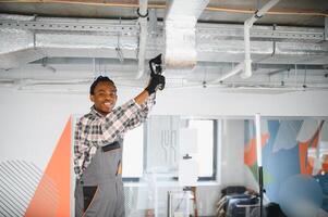 Hvac technician installing air conditioning system in modern office photo