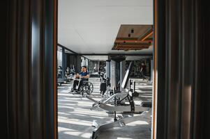 Patient doing rehabilitation exercises in wheelchair at the gym photo