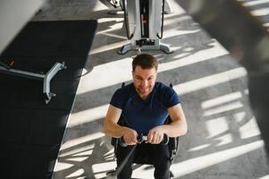 Man with disability working out using cable machine in gym for rehabilitation photo