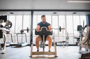 Determined man lifting weights in a modern gym for rehabilitation and recovery photo
