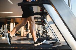 Man running on treadmill in modern gym for rehabilitation photo