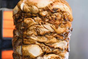 Delicious shawarma rotating on a spit getting cooked by an electric heater photo